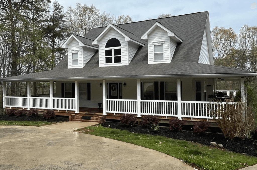 White farmhouse with clean wet driveway after pressure washing